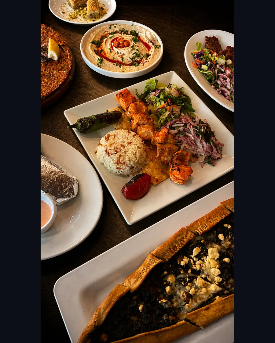 Chicken shish, hummus, lahmacun and pide table spread